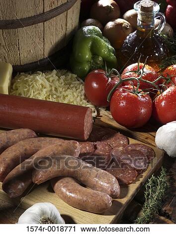 Stock Image - High angle view of sausage and salami on a cutting board. Fotosearch