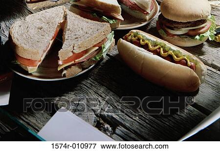 Hot dog and a burger near a plate with a sandwich View Large Photo Image Stock Photo - Hot dog and a burger near a plate with a sandwich. Fotosearch