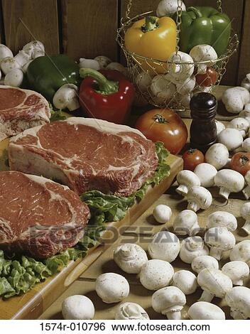 Stock Photograph - Raw meat with mushrooms and vegetables. Fotosearch