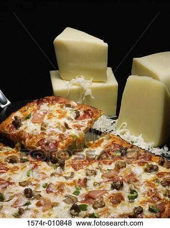 Stock Photo - Wedges of cheese near a pizza. Fotosearch