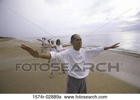 Group of people exercising on the beach View Large Photo Image Stock Image - Group of people exercising on the beach. Fotosearch