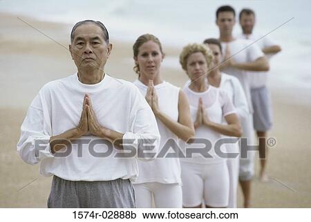 Group of people meditating on the beach View Large Photo Image Stock Image - Group of people meditating on the beach. Fotosearch