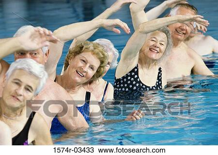 Stock Image - Group of senior people performing water aerobics in a swimming pool. Fotosearch