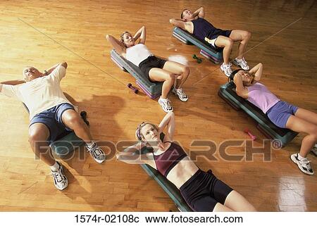 Stock Image - High angle view of a group of people exercising in a step aerobics class. Fotosearch