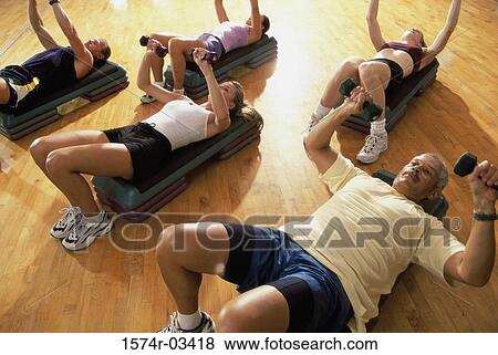 Stock Photo - High angle view of a group of people exercising in a step aerobics class. Fotosearch