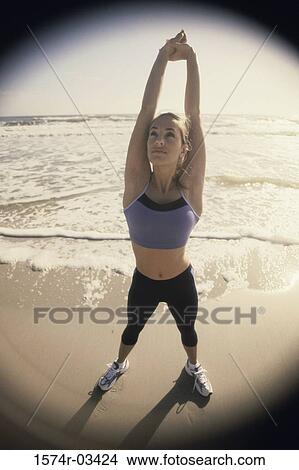 High angle view of a young woman exercising on the beach View Large Photo Image Picture - High angle view of a young woman exercising on the beach. Fotosearch