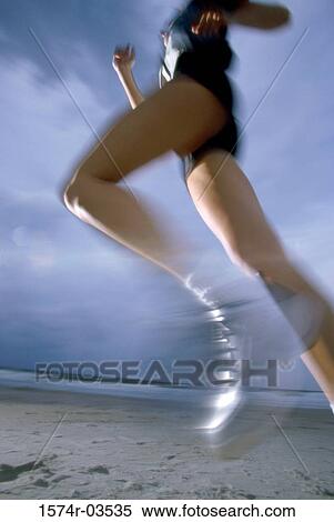 Low angle view of a young woman jogging on the beach View Large Photo Image Stock Photography - Low angle view of a young woman jogging on the beach. Fotosearch