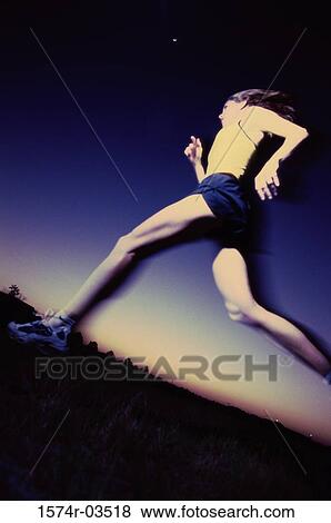 Low angle view of a young woman running View Large Photo Image Stock Photo - Low angle view of a young woman running. Fotosearch