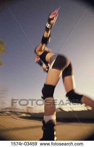 Low angle view of a young woman skating View Large Photo Image Stock Photo - Low angle view of a young woman skating. Fotosearch
