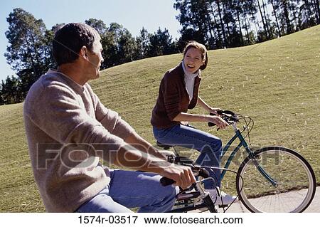 Mid adult couple riding bicycles View Large Photo Image Stock Photo - Mid adult couple riding bicycles. Fotosearch