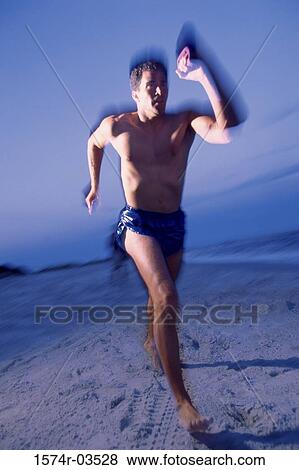 Mid adult man jogging on the beach View Large Photo Image Stock Photo - Mid adult man jogging on the beach. Fotosearch