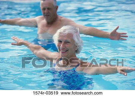 Portrait of a senior couple stretching in a swimming pool View Large Photo Image Stock Photo - Portrait of a senior couple stretching in a swimming pool. Fotosearch