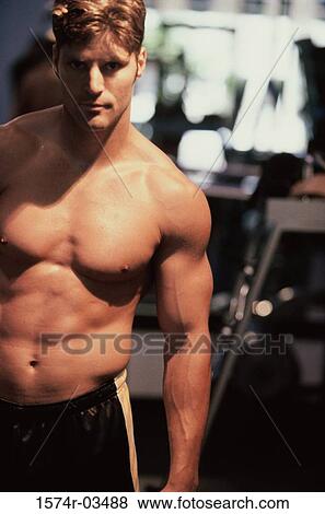 Stock Photo - Portrait of a young man exercising in a health club. Fotosearch