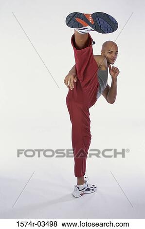 Portrait of a young man kicking with his leg View Large Photo Image Stock Photo - Portrait of a young man kicking with his leg. Fotosearch