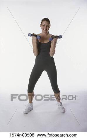 Portrait of a young woman exercising with dumbbells View Large Photo Image Stock Photo - Portrait of a young woman exercising with dumbbells. Fotosearch