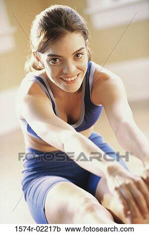 Portrait of a young woman stretching on the floor View Large Photo Image Stock Image - Portrait of a young woman stretching on the floor. Fotosearch