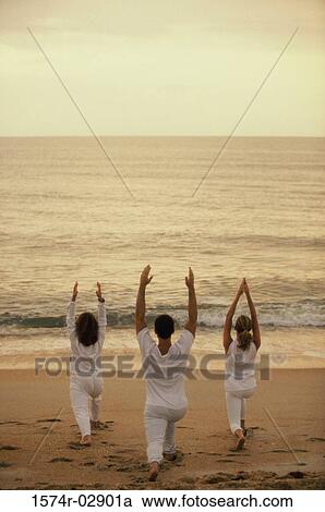 Rear view of two women and a man exercising on the beach View Large Photo Image Stock Image - Rear view of two women and a man exercising on the beach. Fotosearch
