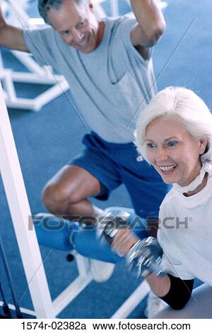 Senior couple exercising in a health club View Large Photo Image Stock Image - Senior couple exercising in a health club. Fotosearch