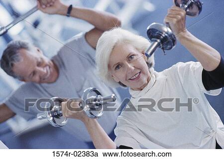 Senior couple exercising in a health club View Large Photo Image Stock Image - Senior couple exercising in a health club. Fotosearch