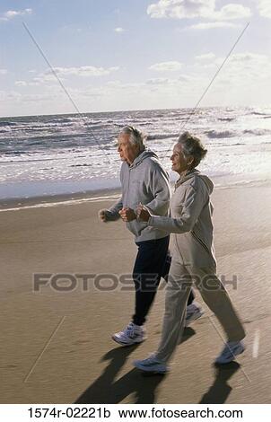 Senior couple walking on the beach View Large Photo Image Stock Image - Senior couple walking on the beach. Fotosearch