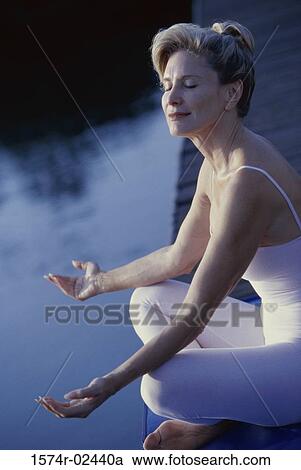 Stock Image - Side profile of a mid adult woman meditating. Fotosearch