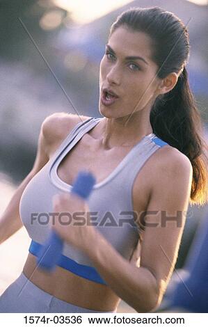 Side profile of a young woman exercising View Large Photo Image Stock Photograph - Side profile of a young woman exercising. Fotosearch