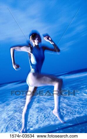 Side profile of a young woman jogging on the beach View Large Photo Image Picture - Side profile of a young woman jogging on the beach. Fotosearch
