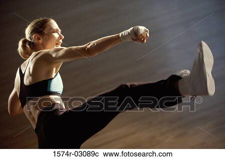 Side profile of a young woman kickboxing View Large Photo Image Stock Image - Side profile of a young woman kickboxing. Fotosearch