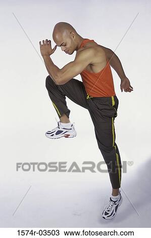 Side profile of young man lifting his leg View Large Photo Image Stock Image - Side profile of young man lifting his leg. Fotosearch