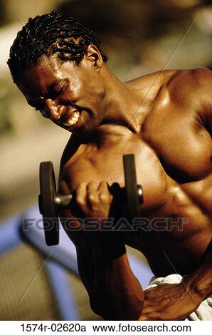 Young man exercising with a dumbbell View Large Photo Image Stock Image - Young man exercising with a dumbbell. Fotosearch