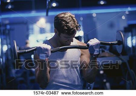 Young man exercising with barbells View Large Photo Image Stock Photo - Young man exercising with barbells. Fotosearch