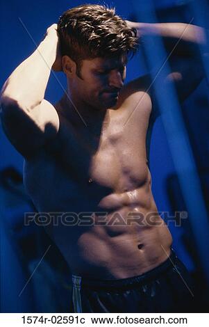 Stock Image - Young man flexing his muscles. Fotosearch