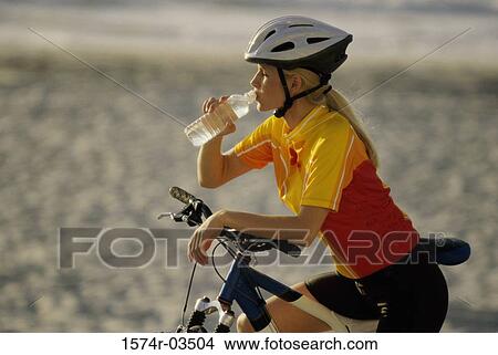 Picture - Young woman drinking from water bottle. Fotosearch