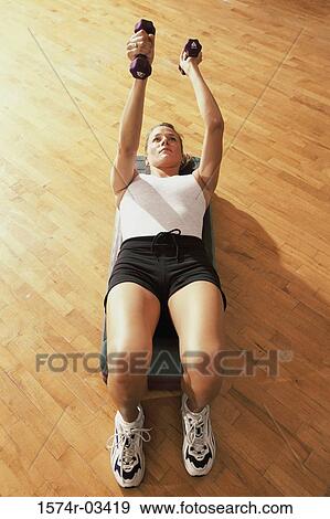 Young woman exercising in a step aerobics class View Large Photo Image Stock Photo - Young woman exercising in a step aerobics class. Fotosearch