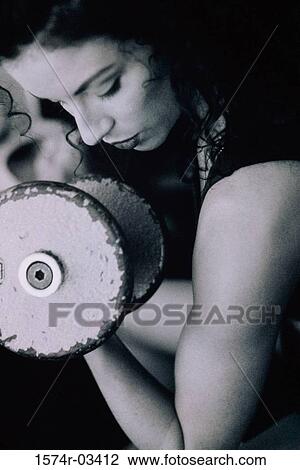 Young woman exercising with dumbbells View Large Photo Image Stock Image - Young woman exercising with dumbbells. Fotosearch