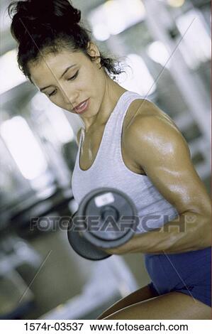 Young woman exercising with dumbbells View Large Photo Image Stock Photo - Young woman exercising with dumbbells. Fotosearch