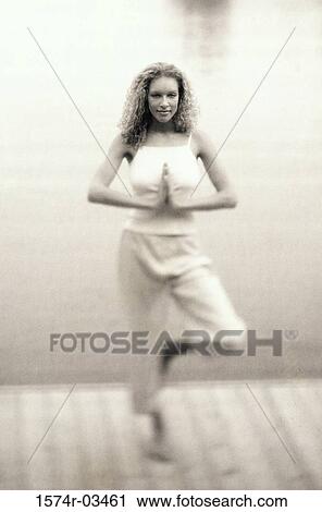 Young woman standing in the tree pose View Large Photo Image Stock Image - Young woman standing in the tree pose. Fotosearch