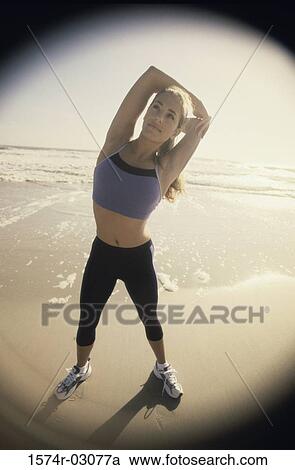 Young woman stretching on the beach View Large Photo Image Stock Image - Young woman stretching on the beach. Fotosearch
