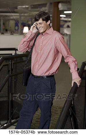 Businessman walking down stairs talking on a mobile phone View Large Photo Image Stock Image - Businessman walking down stairs talking on a mobile phone. Fotosearch