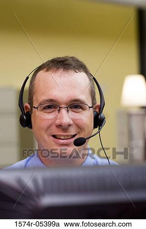 Stock Image - Close-up of a male customer service representative wearing a headset. Fotosearch