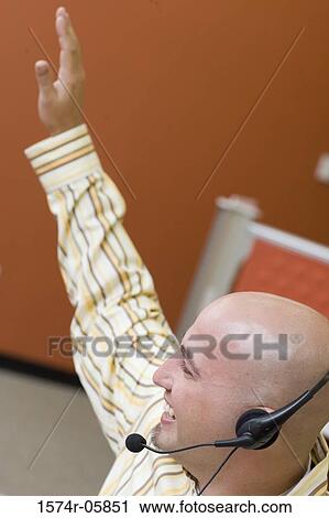 Close-up of a male customer service representative wearing a headset with his hand raised View Large Photo Image Stock Image - Close-up of a male customer service representative wearing a headset with his hand raised. Fotosearch