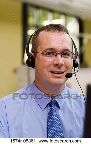 Stock Image - Close-up of a male customer service representative wearing a headset. Fotosearch