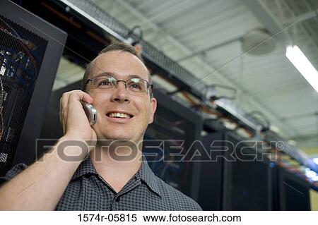 Stock Photography - Close-up of a male technician talking on a mobile phone. Fotosearch