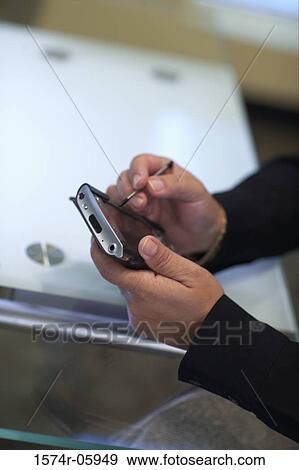 Stock Photo - Close-up of a person's hands holding a palmtop. Fotosearch