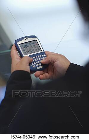 Close-up of a person's hands holding a palmtop View Large Photo Image Stock Photograph - Close-up of a person's hands holding a palmtop. Fotosearch