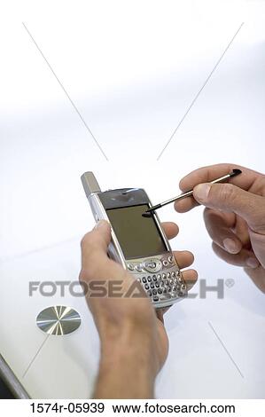 Stock Photo - Close-up of a person's hands using a palmtop. Fotosearch