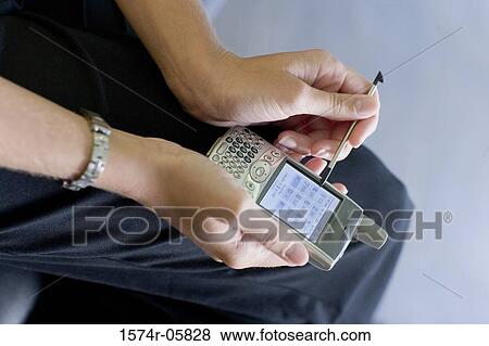 Close-up of a person's hands working on a palmtop View Large Photo Image Stock Photo - Close-up of a person's hands working on a palmtop. Fotosearch