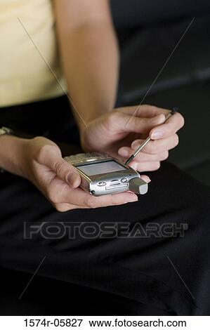 Mid section view of a businesswoman working on a palmtop View Large Photo Image Stock Photo - Mid section view of a businesswoman working on a palmtop. Fotosearch