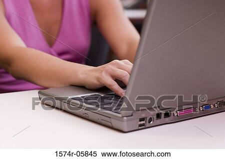 Stock Photography - Mid section view of a businesswoman working on a laptop. Fotosearch