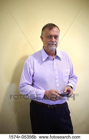 Portrait of a businessman holding a palmtop View Large Photo Image Stock Image - Portrait of a businessman holding a palmtop. Fotosearch